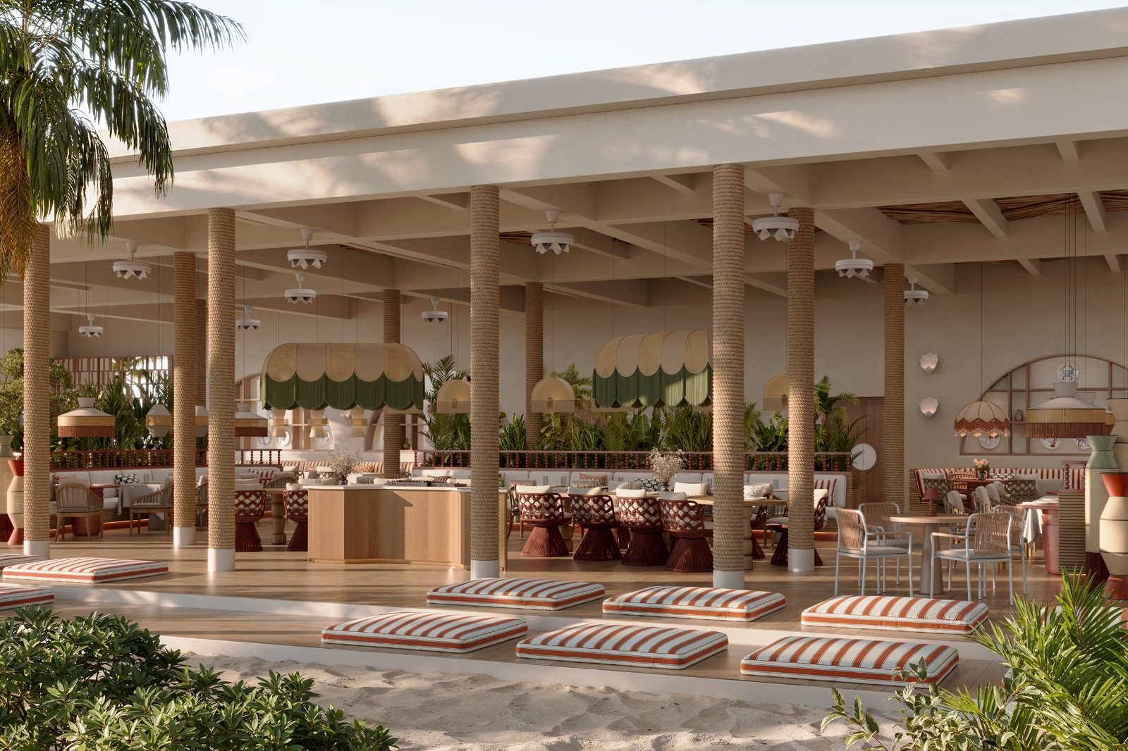 Beachfront pavilion with striped floor cushions on the sand